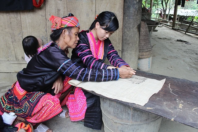 Phụ nữ dân tộc Mông bản Cổng Trời truyền dạy kỹ thuật tạo hoa văn cho thế hệ trẻ.