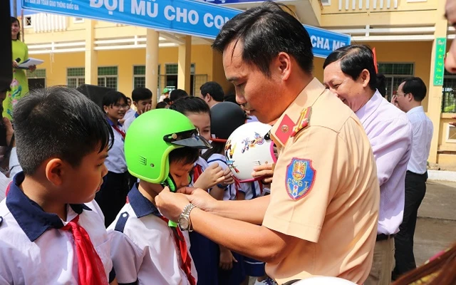 Trao mũ bảo hiểm cho học sinh tiểu học tại tỉnh Đồng Tháp. (Ảnh: Cục CSGT)