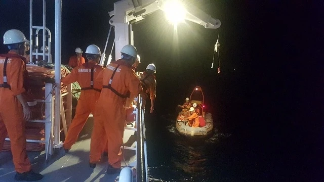 Các thuyền viên tàu SAR 412 đưa nạn nhân về tàu.