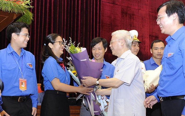 Tổng Bí thư, Chủ tịch nước Nguyễn Phú Trọng tặng hoa các đảng viên trẻ tiêu biểu tại buổi gặp mặt. Ảnh: ĐĂNG KHOA