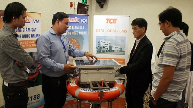 Đại biểu tìm hiểu thiết hệ thống giám sát chất lượng nước online được trưng bày tại Hội nghị. Ảnh: TIẾN LỰC ·TTXVN