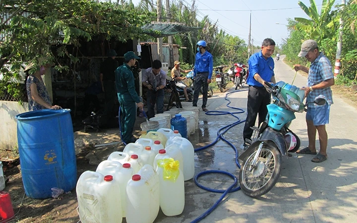 Người dân xã Tân Tập, huyện Cần Giuộc xếp hàng mua nước sạch.