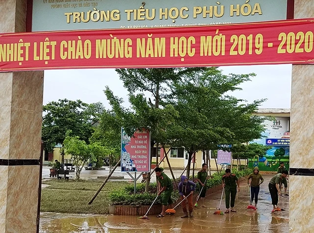 Công an huyện và giáo viên Trường tieeur học Phù Hóa (Quảng Bình) dọn vệ sinh sân trường sau lũ.