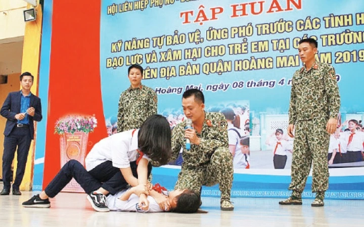 Chiến sĩ Tiểu đoàn Đặc công 18 hướng dẫn động tác tự vệ cho học sinh Trường THCS Tân Mai, quận Hoàng Mai. Ảnh: THỦY TIÊN