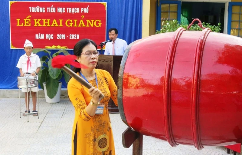 Hiệu trưởng Trường tiểu học Trạch Phổ (Phong Hòa) Hà Thị Hiền đánh trống khai giảng năm học mới 2019-2020. (Ảnh: THANH HẢI)