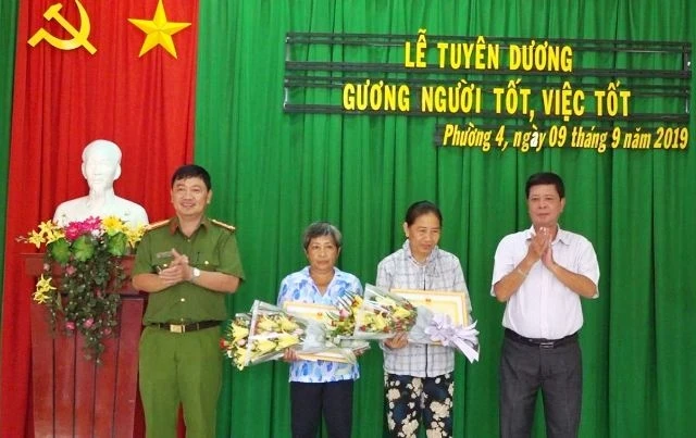 Lãnh đạo UBND TP Sa Đéc và Công an TP Sa Đéc trao giấy khen, hoa cho bà Trần Thị Tư (trái) và bà Nguyễn Thị Thu Thảo (phải). 