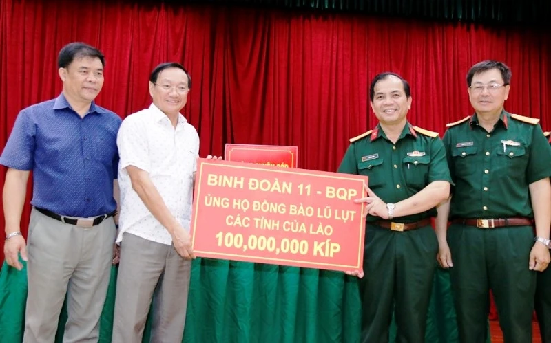 Đại sứ Nguyễn Bá Hùng (áo trắng) tiếp nhận số tiền quyên góp tại buổi lễ.