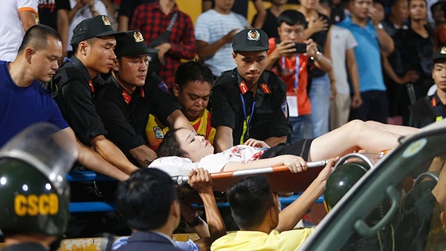 Một nữ khán giả bị thương do pháo sáng của CĐV Nam Định. Ảnh: MINH KHIẾU