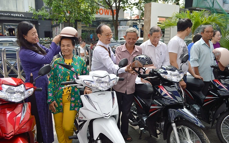 Ðại diện Ủy ban MTTQ thành phố Hồ Chí Minh trao phương tiện sinh kế cho các hộ dân có hoàn cảnh khó khăn.