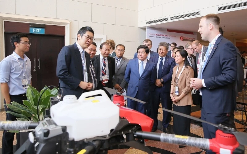 Thứ trưởng Lê Quốc Doanh và các đại biểu tham quan các máy móc hiện đại trưng bày tại Diễn đàn.