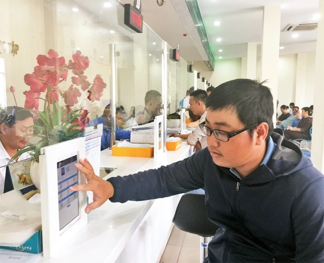 Sau khi nộp hồ sơ hành chính tại Bộ phận tiếp nhận hồ sơ quận Bình Tân, người dân sử dụng hệ thống máy tính bảng để đánh giá sự hài lòng về chất lượng dịch vụ.