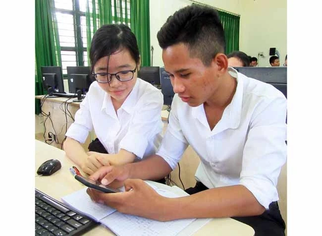 Hai học sinh Pi Năng Bảo và Mai Vỹ Hào trong quá trình nghiên cứu, sáng chế ứng dụng học tiếng Ra Glai.
