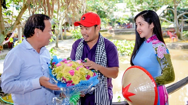 Anh Phong tặng hoa thắt bằng lá dừa cho đại diện khách du lịch.