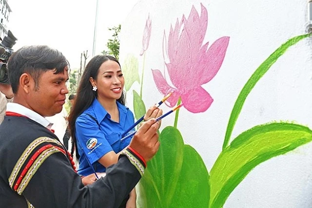 "Siêu nhân dọn rác" Y Hlý Niê Kdăm cùng đoàn viên, thanh niên và thiếu nhi vẽ tranh tường cổ động bảo vệ môi trường tại buổi lễ.