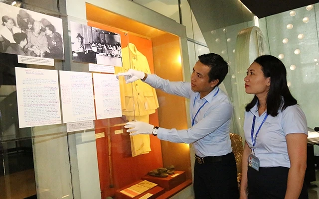 Cán bộ Bảo tàng Hồ Chí Minh (Ðào Tuấn Anh và Nguyễn Thu Huyền) bên các tài liệu, hiện vật về Chủ tịch Hồ Chí Minh.
