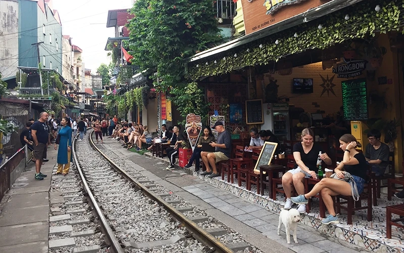 Hàng chục quán cà-phê "mọc" sát đường tàu thu hút đông đảo khách du lịch nước ngoài đến trải nghiệm.