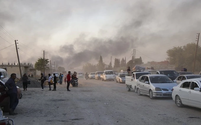 Người dân Syria rời khỏi khu vực bị quân đội Thổ Nhĩ Kỳ nã pháo tại thị trấn Ras Al-Ayn, ngày 9-10. (Ảnh: AP)