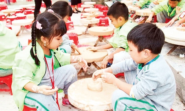 Trẻ em học làm gốm ở làng Bát Tràng.