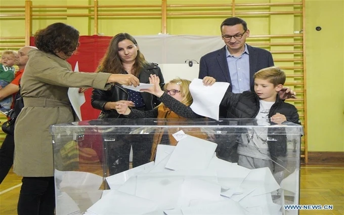 Thủ tướng Ba Lan Mateusz Morawiecki và gia đình bỏ phiếu tại một điểm bầu cử tại Warsaw, ngày 13-10. (Ảnh: Tân Hoa xã)