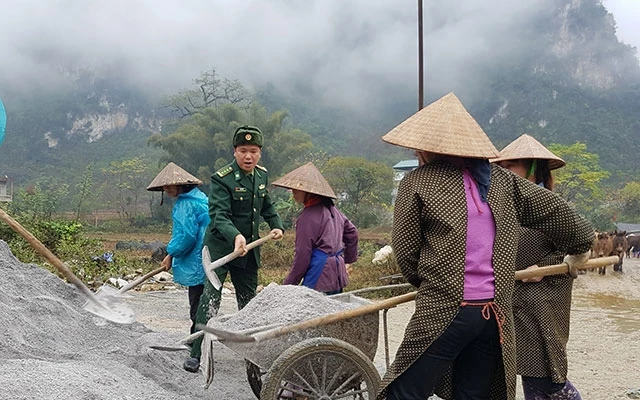 Thượng tá Mê Văn Đạt, Bí thư Đảng ủy xã Đàm Thủy cùng làm đường với dân.