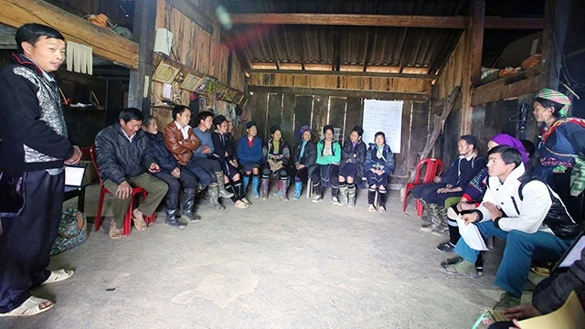 Anh Má A Pho (người đứng, xã Sa Pả, huyện Sa Pa, Lào Cai) phổ biến thông tin mới trong buổi họp ở một bản người Mông.