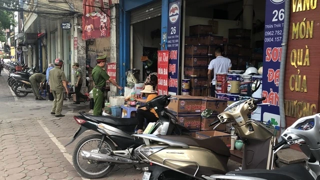 Lực lượng Công an phường Dịch Vọng Hậu (quận Cầu Giấy, Hà Nội) kiểm tra, nhắc nhở những hộ kinh doanh để xe đúng nơi quy định.