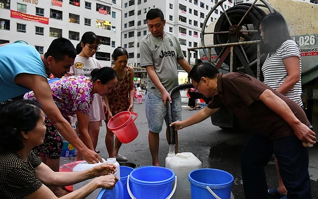 Nhiều hộ dân xếp hàng để lấy nước tại tòa chung cư HH thuộc Khu đô thị Linh Đàm, quận Hoàng Mai, Hà Nội (Ảnh: Thủy Nguyên).