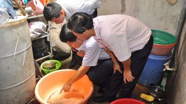 Sở Y tế Hà Nội hướng dẫn người dân kiểm tra dụng cụ chứa nước có bọ gậy. Ảnh: GP
