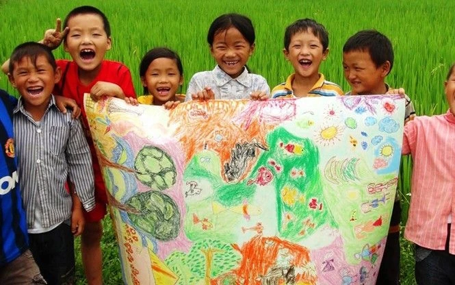 Trẻ em vùng cao Hà Giang bên một bức tranh do các em cùng vẽ. Ảnh: LINH NGUYỄN