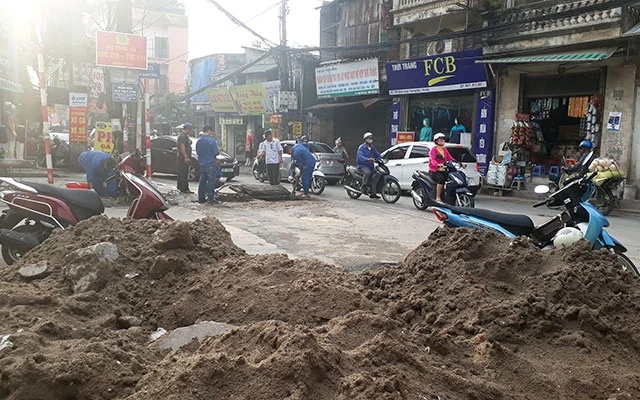 Những công trình xây dựng không che chắn, gây phát thải bụi tồn tại trên nhiều tuyến phố nội đô Hà Nội.