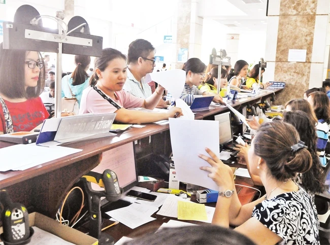 Đại diện các doanh nghiệp làm thủ tục kê khai nộp thuế tại trụ sở Cục Thuế TP Hồ Chí Minh.