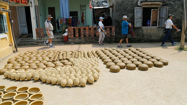 Nhiều khách du lịch đến tham quan, tìm hiểu về làng gốm. Ảnh: MINK