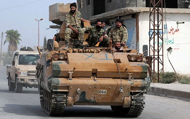 Các tay súng Syria được Thổ Nhĩ Kỳ hậu thuẫn tiến vào thị trấn biên giới Tel Abyad, miền bắc Syria. Ảnh REUTERS