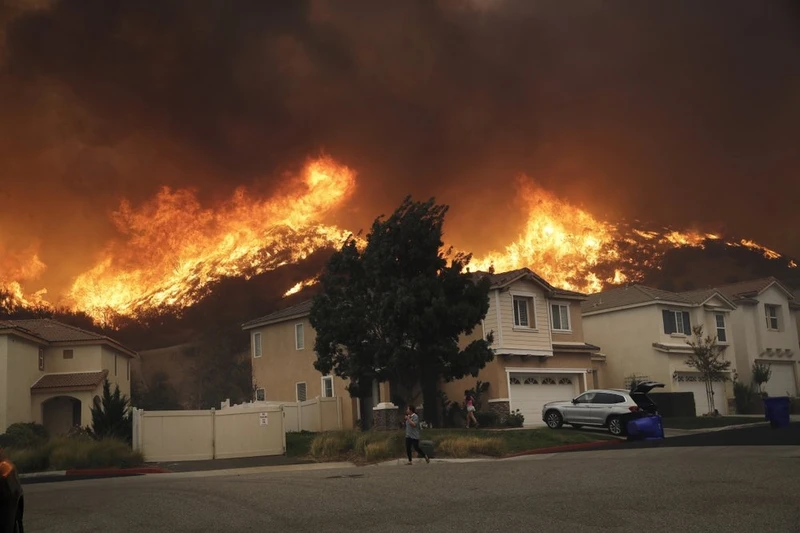 Đám cháy bùng phát dữ dội lan tới dần khu vực nhà dân ở Santa Clarita, California (Ảnh: AP)