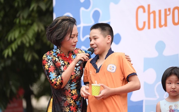 Thái Thùy Linh trò chuyện với trẻ em trong chương trình nghệ thuật đường phố nâng cao nhận thức về người tự kỷ.