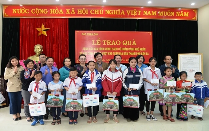 Đoàn công tác của Báo Nhân Dân và đại diện lãnh đạo thành phố Sơn La trao quà cho các học sinh nghèo vượt khó trên địa bàn thành phố.