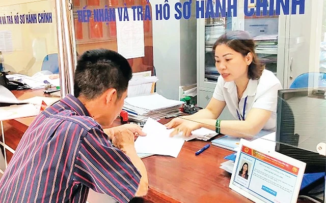 Cán bộ tại Bộ phận một cửa phường Nguyễn Du, quận Hai Bà Trưng giải quyết thủ tục hành chính cho người dân. Ảnh: NGUYỄN CÔNG