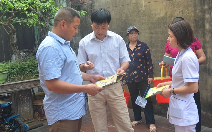 Cán bộ y tế hướng dẫn người dân tại TP Hà Nội thực hiện các biện pháp phòng, chống sốt xuất huyết. Ảnh: VÂN VÂN