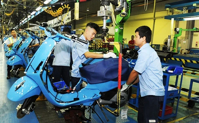 Công nhân Công ty TNHH Piaggio Việt Nam (Khu công nghiệp Bình Xuyên, Vĩnh Phúc) lắp ráp linh kiện xe máy. Ảnh: HÀ CẦU