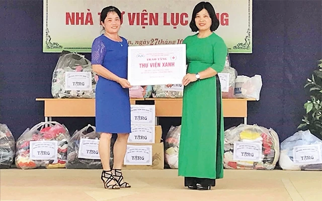 Cô giáo Nguyễn Thị Thủy (bên phải) trao tặng công trình thư viện cho Trường THCS Mường Thìn, huyện Tuần Giáo (Ðiện Biên). 