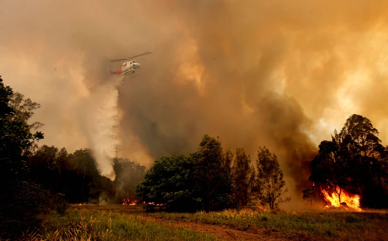 Trực thăng cứu hỏa phun nước nỗ lực dập tắt các đám cháy bùng phát dữ dội (Ảnh: GlobalNews)