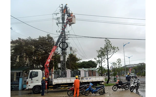 Ðiện lực Bình Ðịnh khắc phục sự cố điện trên đường Tây Sơn, TP Quy Nhơn. Ảnh: NGUYÊN LINH (TTXVN)