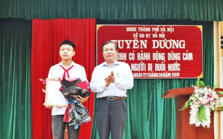 Em Phan Trung Hiếu nhận bằng khen của UBND thành phố về hành động dũng cảm cứu người bị nạn.