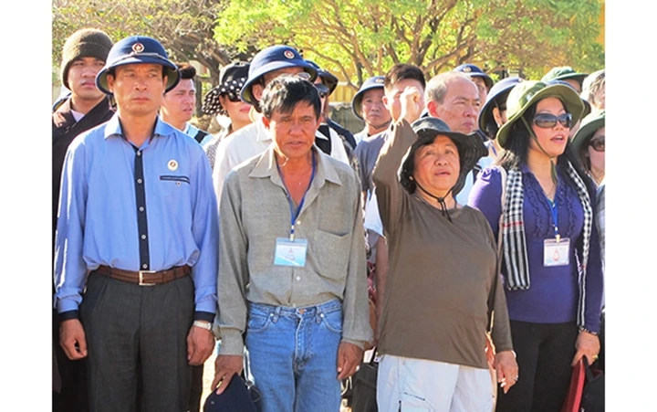 Bà Phùng Tuệ Châu (thứ hai từ phải sang) giơ tay và hô “Xin thề” khi dự lễ chào cờ tại đảo Song Tử Tây tháng 4-2014. Ảnh: Báo Quân đội nhân dân.