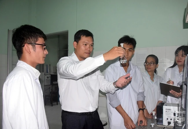 Tiến sĩ Trần Văn Tân (thứ hai từ trái sang) hướng dẫn sinh viên thực hành môn Hóa học.