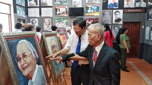 Họa sĩ Trương Văn Ý với các tác phẩm của mình.