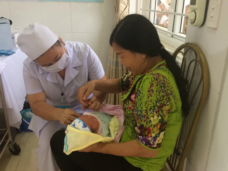 Cán bộ Trạm y tế xã Đoàn Kết (huyện Vân Đồn, tỉnh Quảng Ninh) kiểm tra sức khỏe cho trẻ em trước khi tiêm vắc-xin.