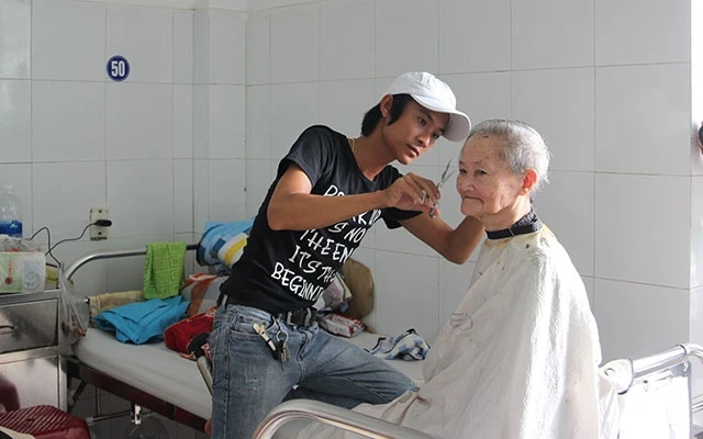 Anh Quang Thảo cắt tóc cho bệnh nhân bệnh nặng ngay tại phòng bệnh.