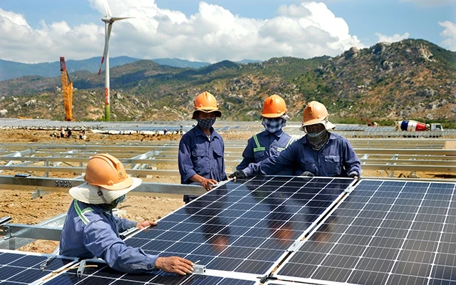 Công nhân lắp đặt tấm pin tại Tổ hợp năng lượng tái tạo điện mặt trời và điện gió Trung Nam ở huyện Thuận Bắc (Ninh Thuận).