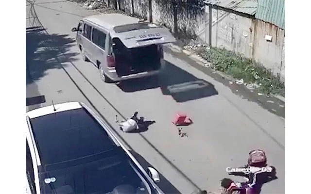 Ba học sinh lớp 1 bị rơi xuống đường từ xe ô-tô đưa đón học sinh. (Ảnh cắt từ clip)